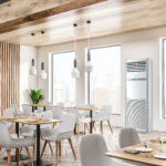 Corner of modern cafe with white walls, wooden floor, loft windows, wooden tables with white chairs and blackboard on the wall. 3d rendering
